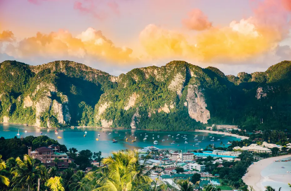 Aerial view of boats departing and arriving from Ko Phi Phi Islands. Sunset and golden clouds in the background