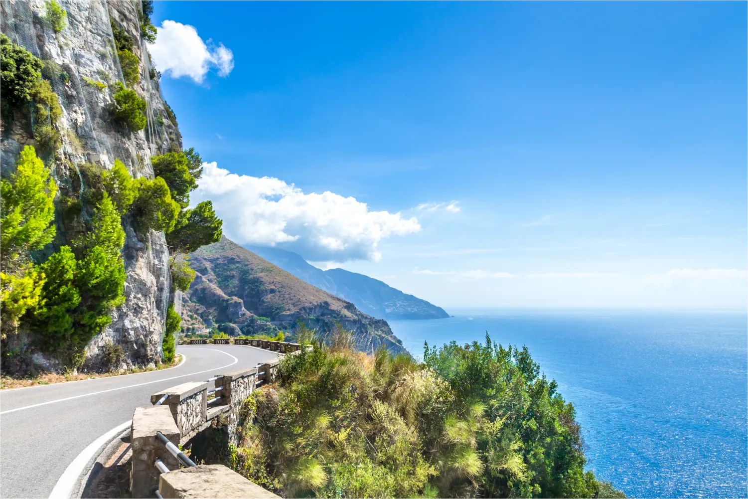 scenic road along the Amalfi Coast with mountains on one side and the sea on the other