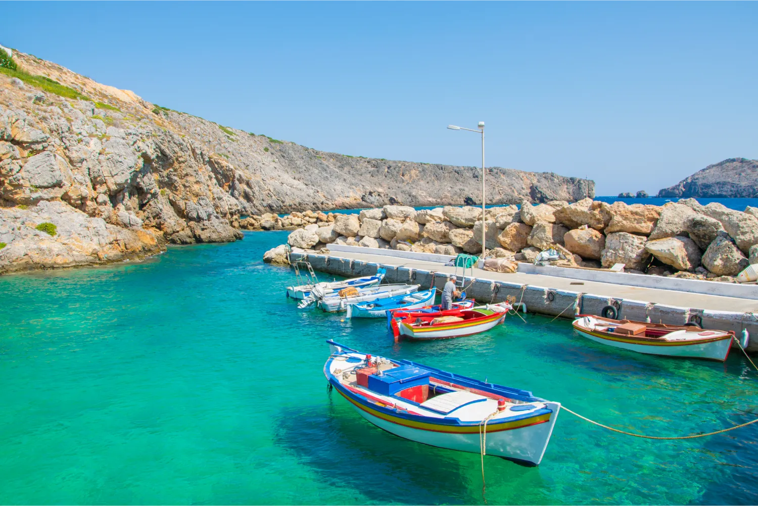 Little Port With Colorful Fishing Boats And Turquoise Sea Waters In Potamos Village In Antikythera