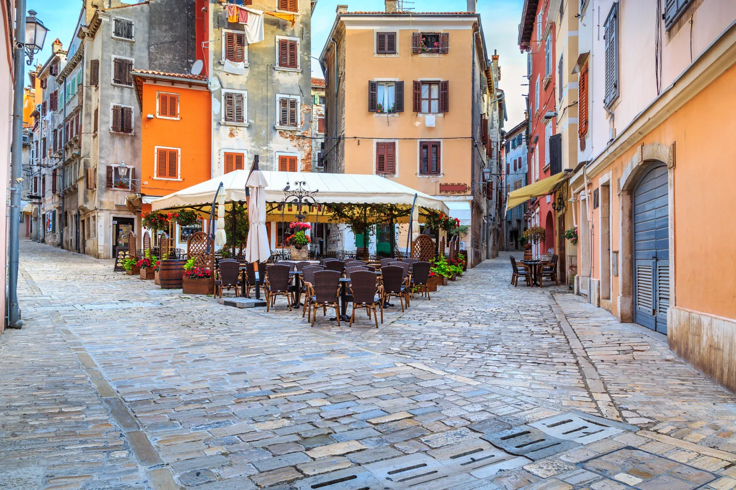 Spectacular Stone Paved Street With Colorful Houses And Typical Street Cafe Bar in Rovinj Old Town