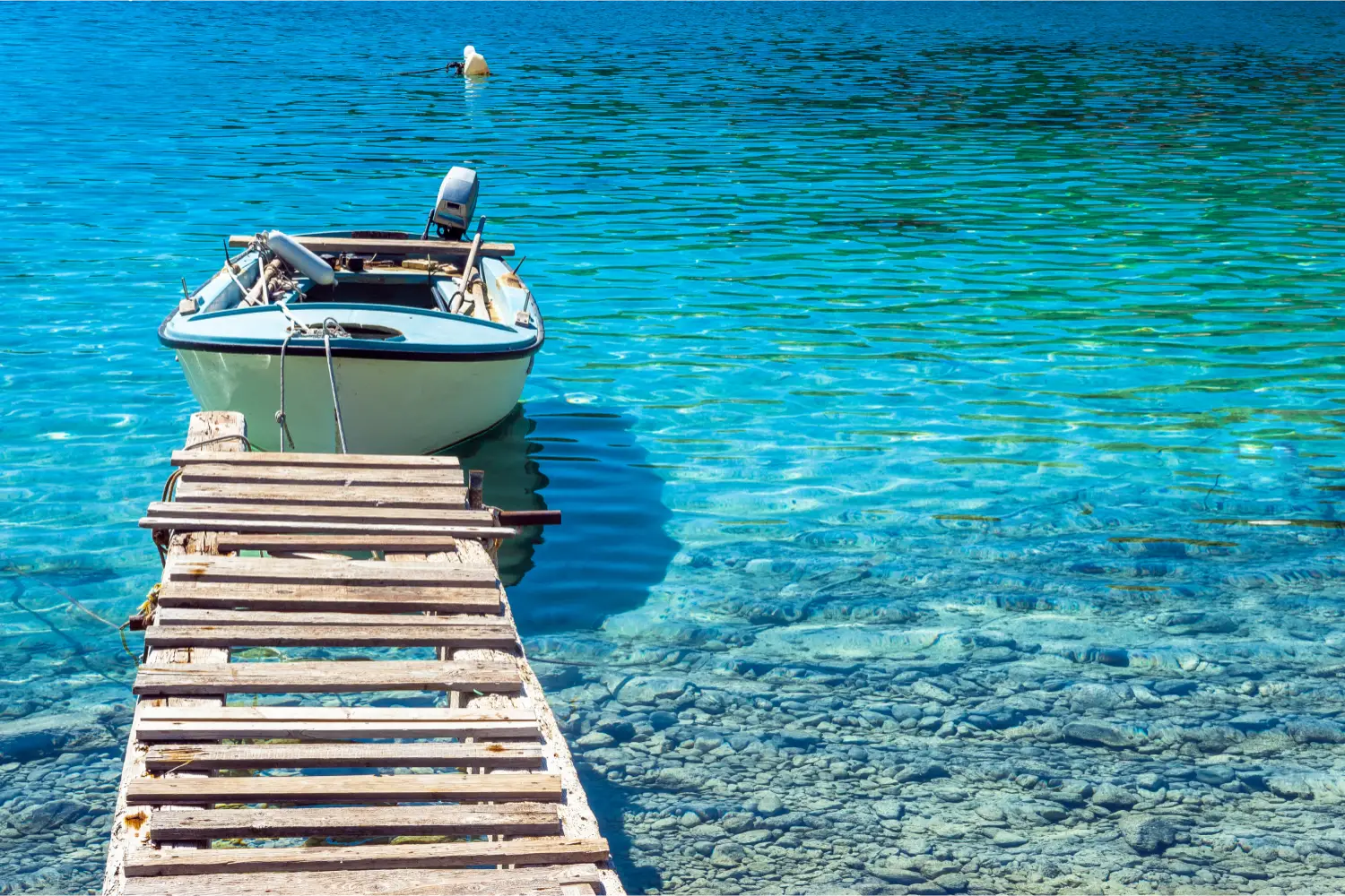 A small fishing boat in the crystal clear sea of Inousses