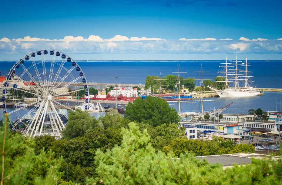 Trees, a ferry wheel and the ferry port of Gdynia, Poland