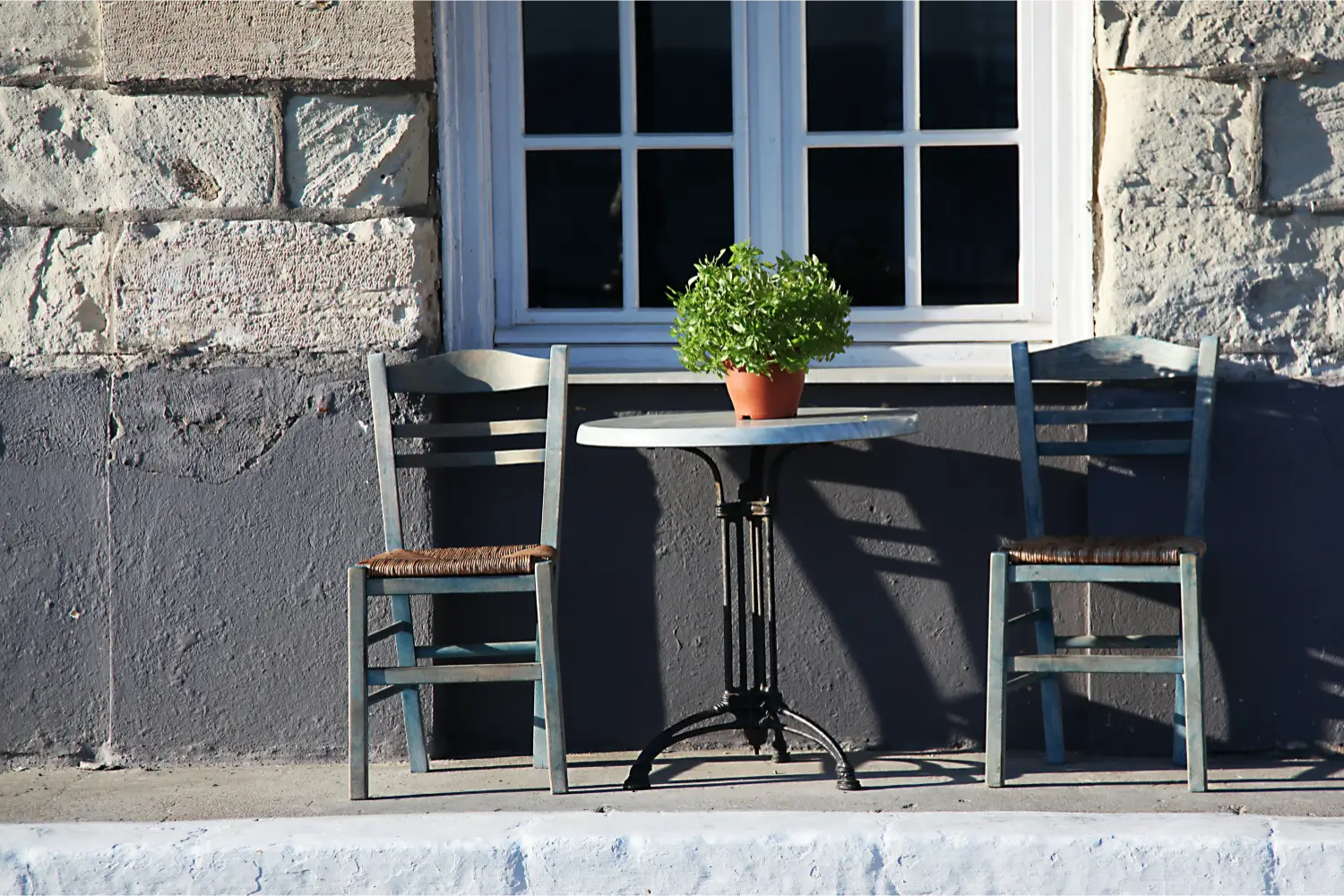 Two chairs and a table outside a traditional house in Mantoudi