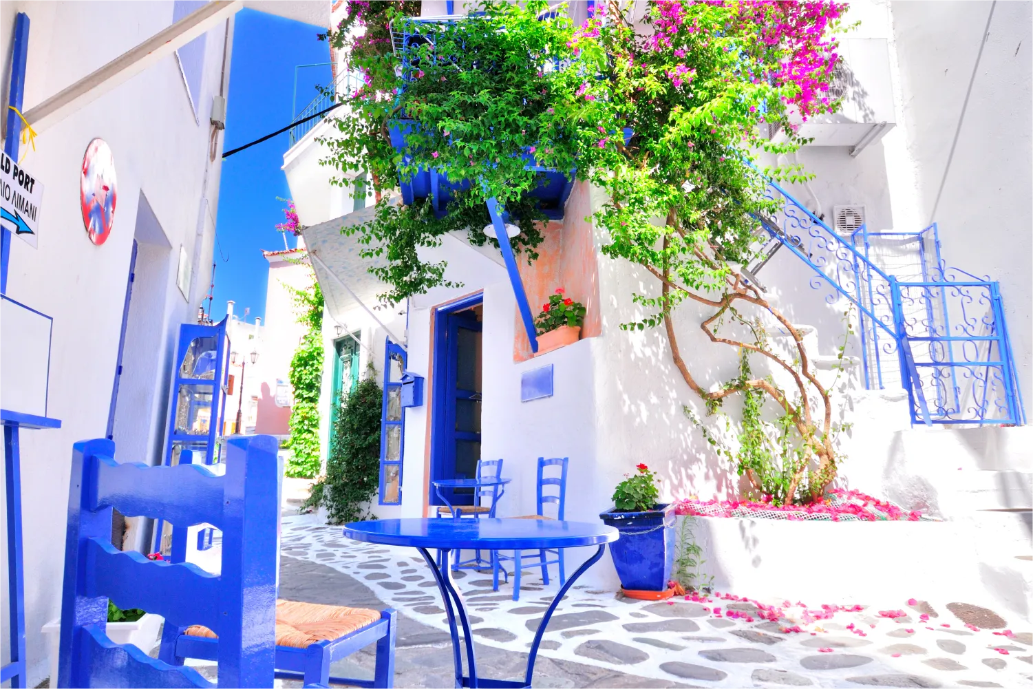 White Walls, Blue Furniture And Colorful Bougainvilla in Skiathos village