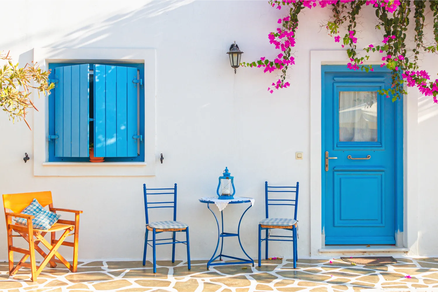 3 chairs and a table outside a traditional house in Antiparos
