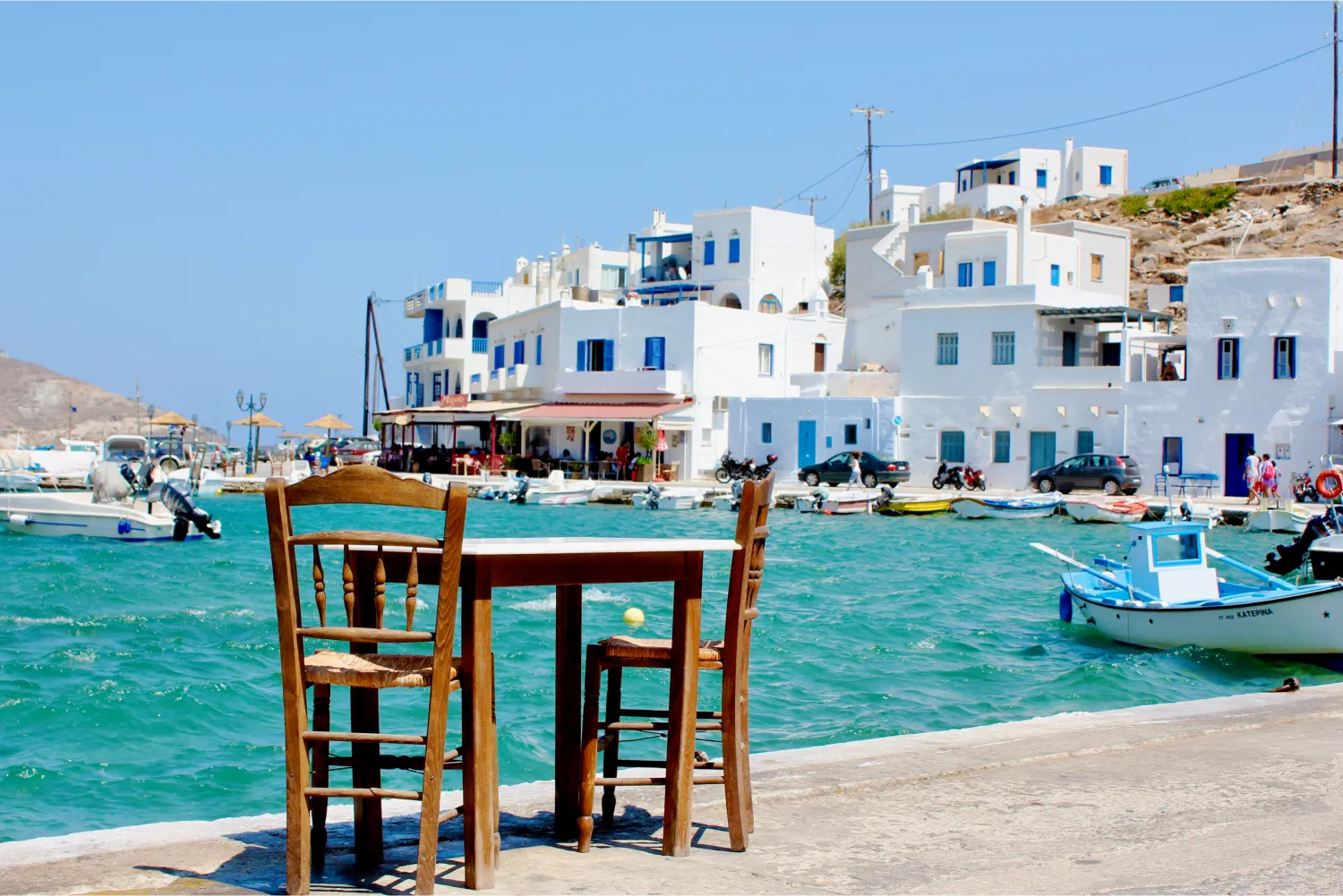 A Table For Two Awaiting Customer By A Quaint Harbour in Tinos