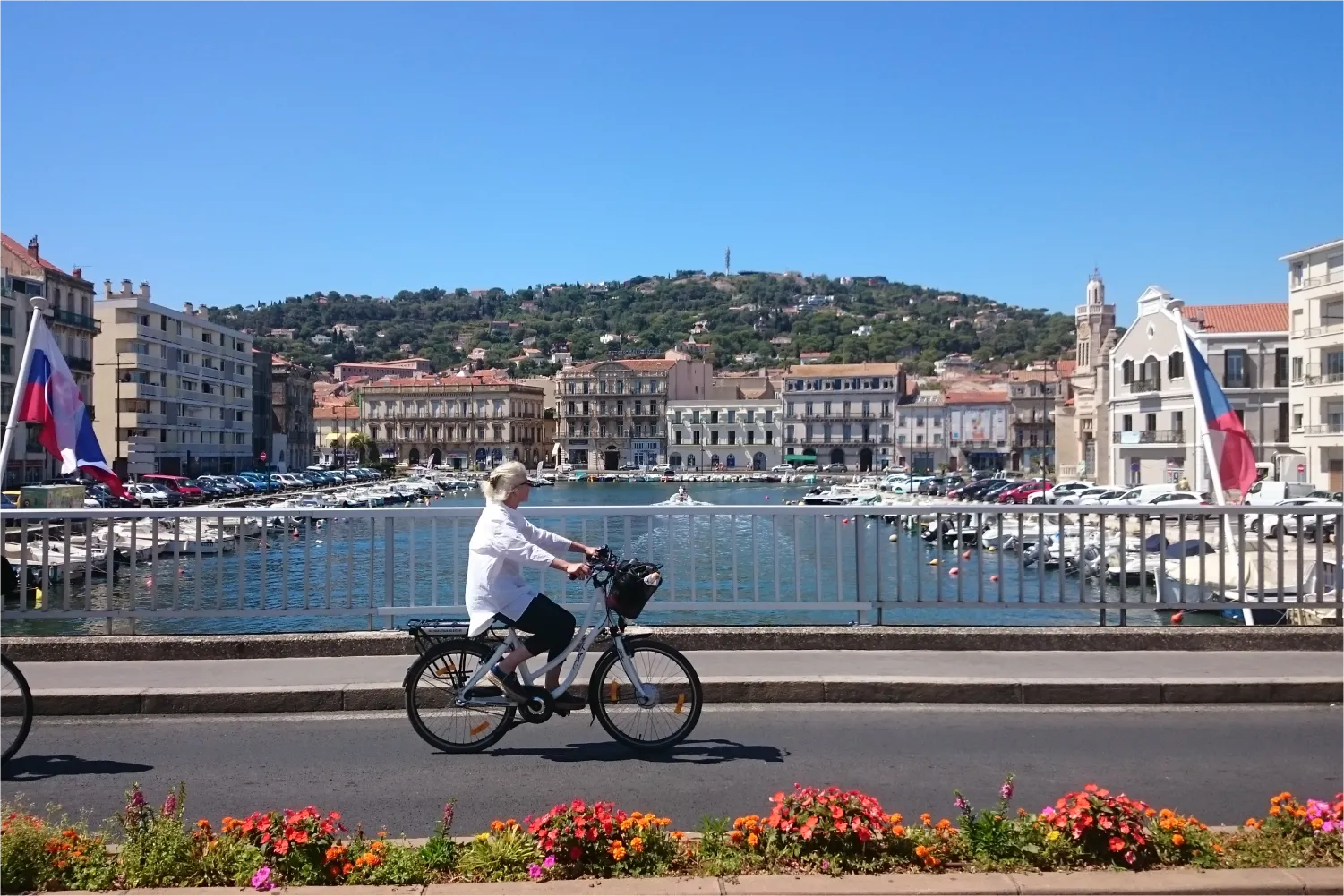 Woman riding her bike along the marina of Sete